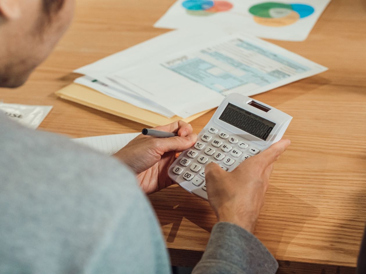 Working through the numbers — calculator, statements, and reports spread across the desk