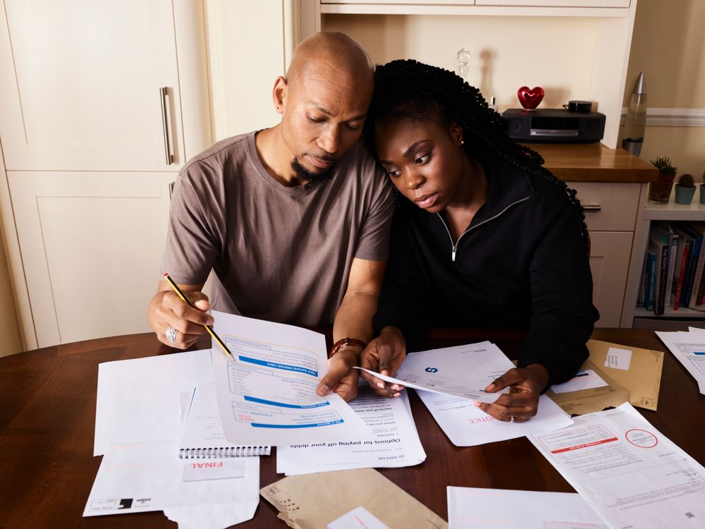 A couple at their kitchen table, working through their paperwork together