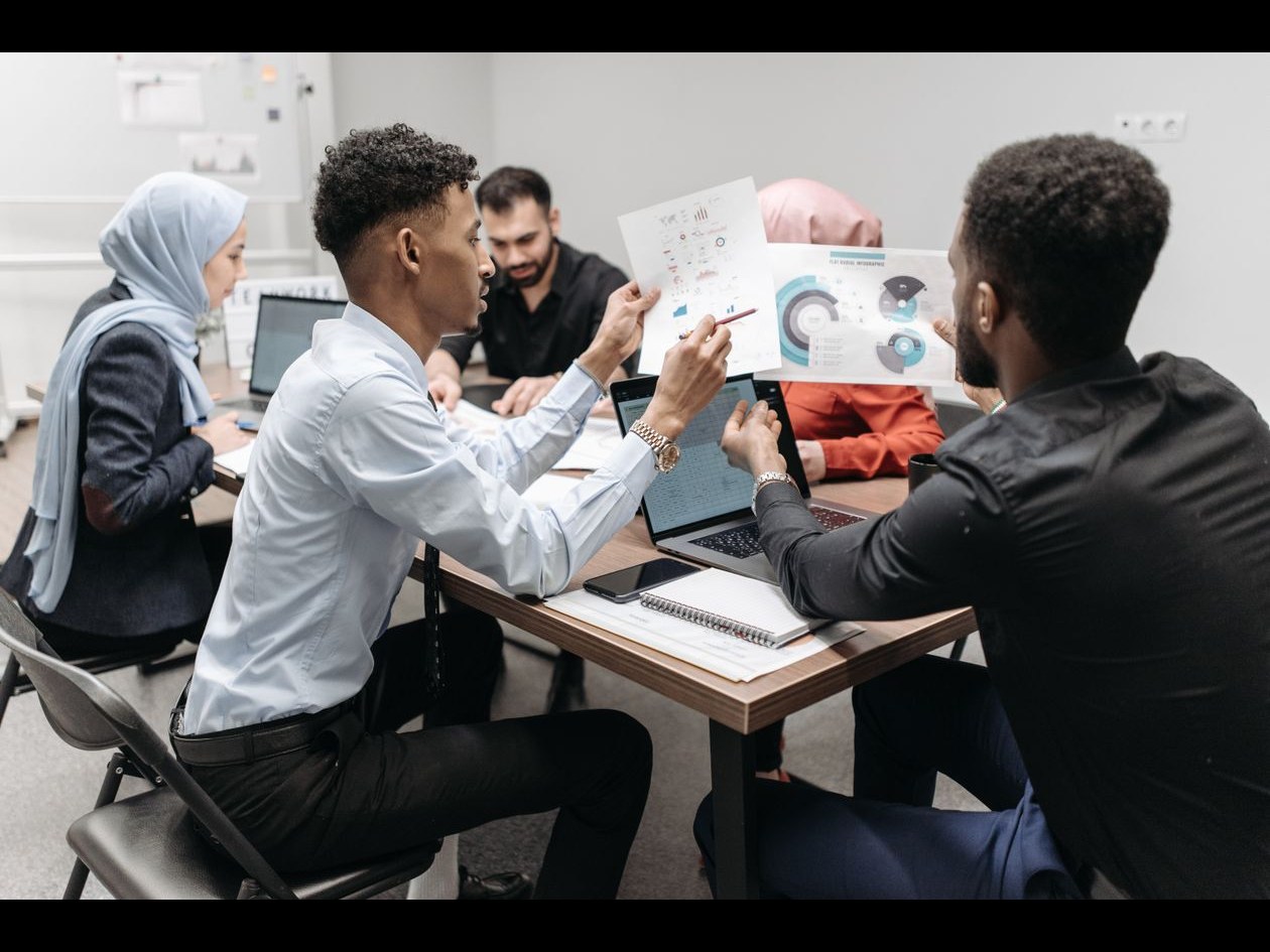 A diverse team of professionals reviewing plans and charts together