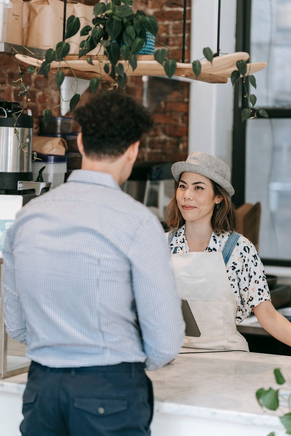 A small business owner serving a customer at her shop counter